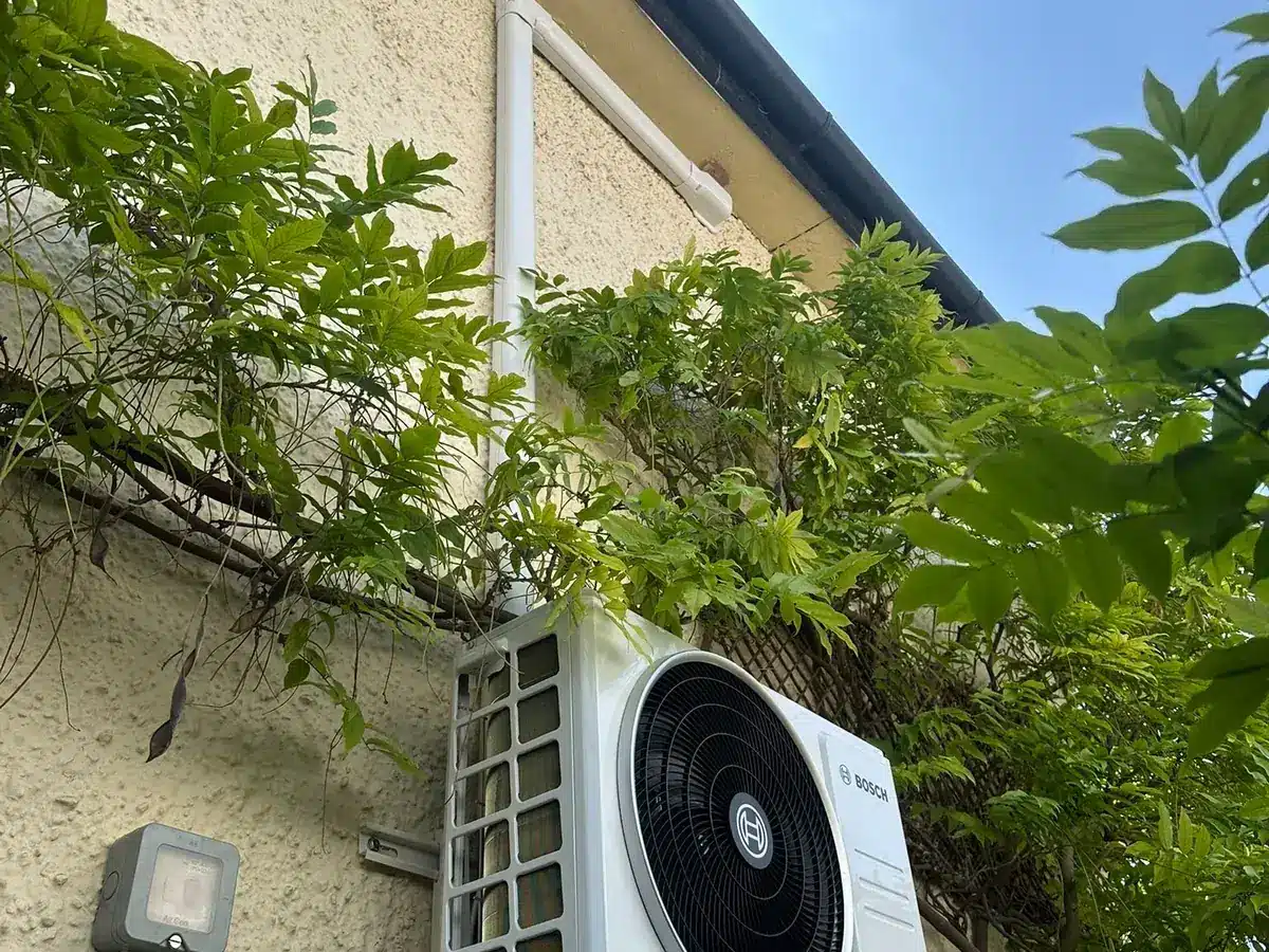 Bosch outdoor unit on a rendered wall surrounded by wisteria