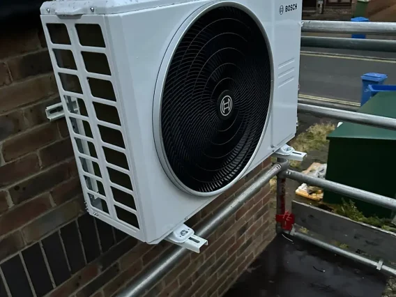 Bosch outdoor unit on wall brackets next to scaffolding during an installation